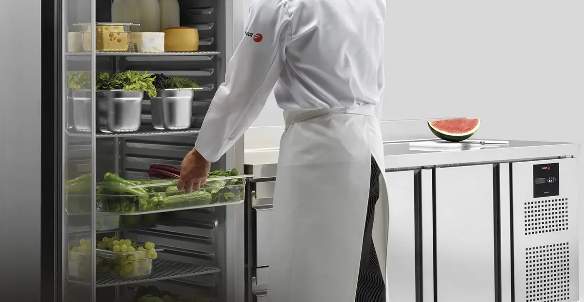 Cocinero guardando género en un armario frigorífico